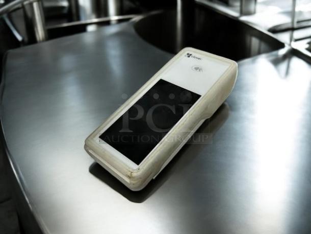 Clover Flex handheld POS system in excellent condition, shown on a metal surface. Screen and NFC symbol visible.