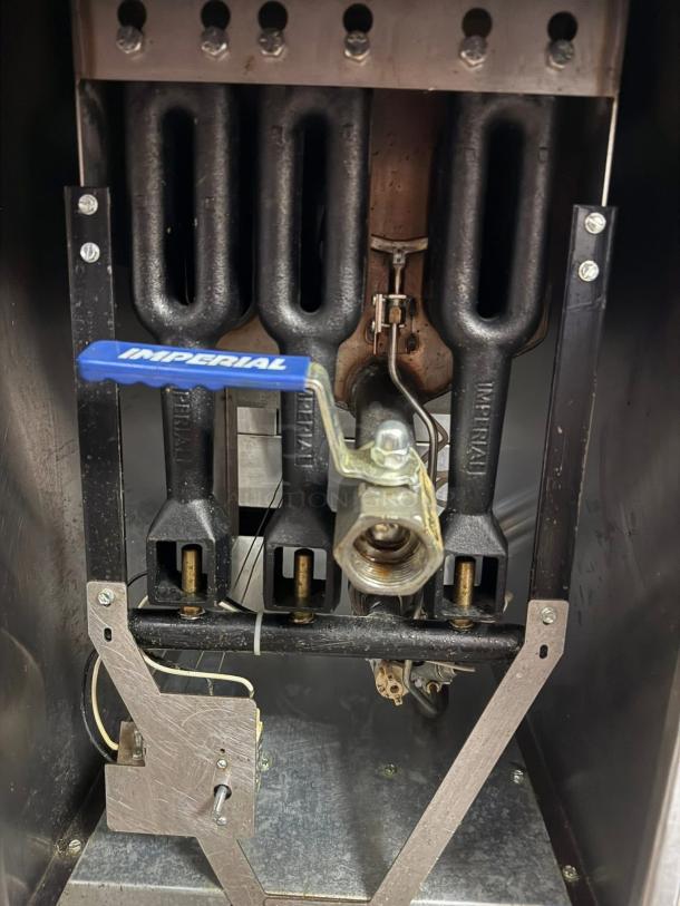 Imperial IFS-40NG fryer interior showing tube-fired burners, blue Imperial handle, and metal fittings. Like new condition.