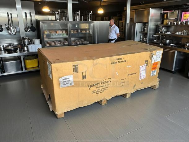 New Henny Penny HHC-900 insulated holding cabinet in original box, labeled "Fragile/Handle With Care," on a pallet.