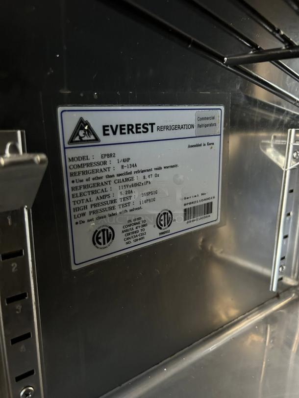 Everest Refrigeration EPBR2 label with model, compressor, refrigerant details, and ETL certification. Stainless steel surface.