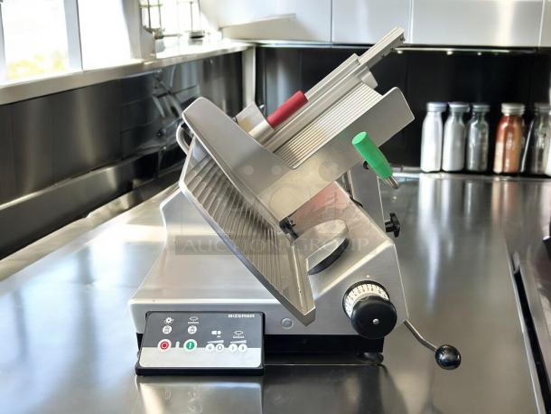 Bizerba Model L-22 meat slicer with 13" blade, aluminum body, safety dial, and control panel; tested and working condition.