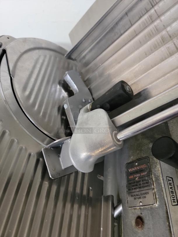 Hobart Model 1712R commercial meat slicer, heavy-duty, stainless steel, visible warning label, ideal for kitchens or delis.
