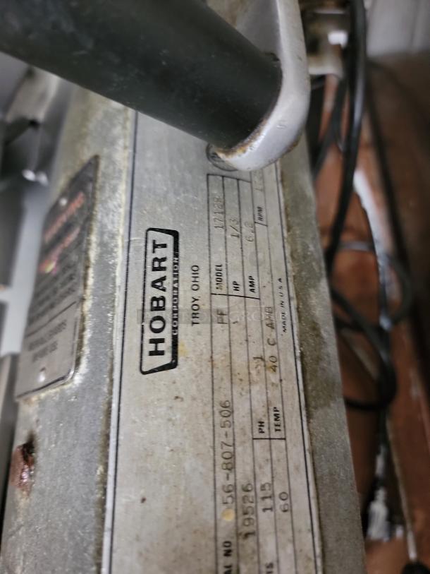 Hobart 1712R commercial meat slicer, showing model label, heavy-duty design, some wear, ideal for kitchens and delis.