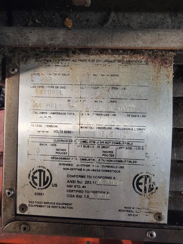 Metal label on Zesto Model 212 gas oven shows specifications. ETL certified, 82,000 BTU, made in Canada.