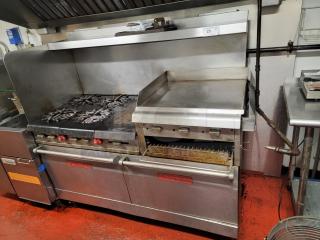 Vulcan 4-burner commercial range with 24" raised griddle/broiler and ovens, stainless steel, used condition, ideal for high-volume cooking.