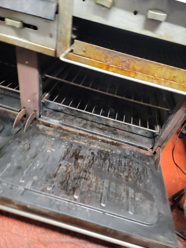 Vulcan 4-burner commercial range with 24" raised griddle/broiler and ovens. Used condition. Buyer must remove.