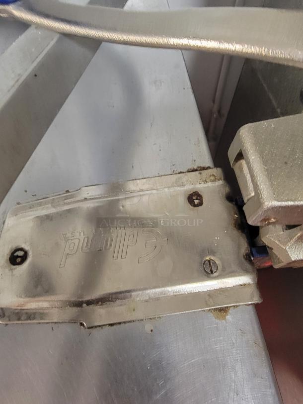 Stainless steel commercial can opener mounted on a work table, part of a hot holding and prep station set.
