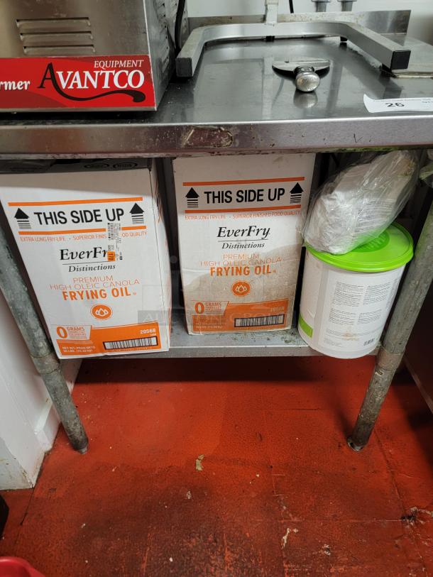 Complete hot holding and prep station with Avantco warmer, dual heat lamps, stainless table, commercial can opener, and frying oil.