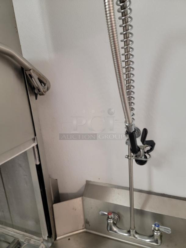 Champion DH6000T commercial hood-type dishwasher with pre-rinse faucet and integrated stainless steel dish tables.