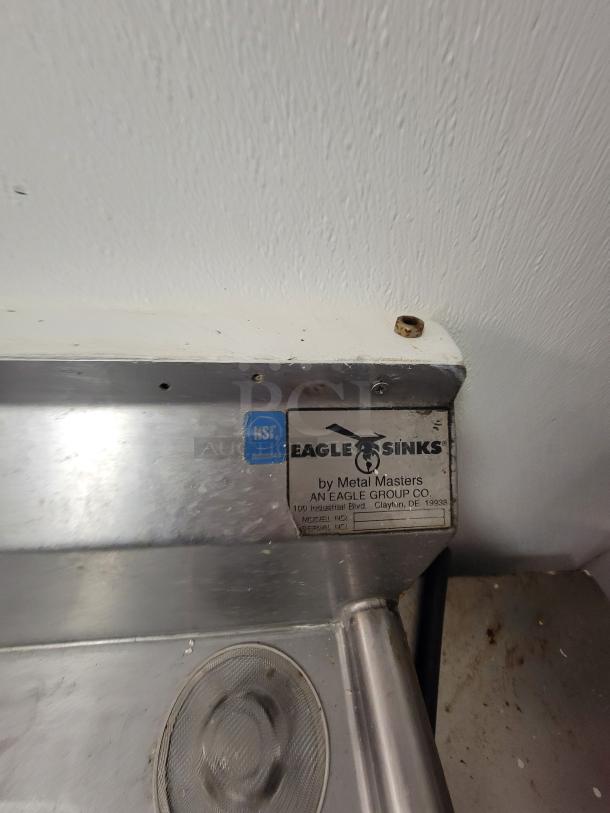 Eagle Sinks 3-compartment stainless steel sink with NSF certification tag, pre-rinse faucet. Model/serial info visible.