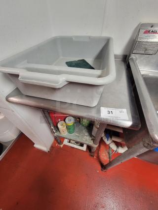 Compact 24" stainless steel work table with cleaning supplies, used condition, label from Eagle indicating cleaning instructions.