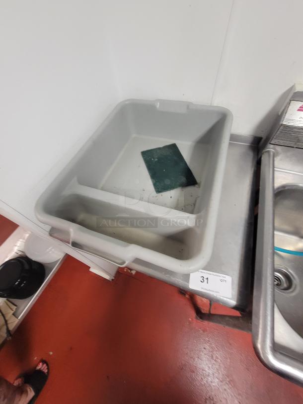 24" stainless steel work table with kitchen supplies. Includes large plastic bin and scouring pad. Auction tag reads "31 QTY".