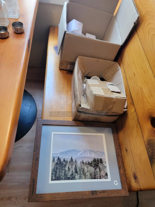 Huge lot of commercial kitchen supplies with open boxes and framed mountain wall art. Ideal for restaurant setup.