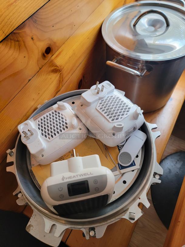 Assorted commercial kitchen supplies including Heatwell devices, large pot with lid, and various small-wares.