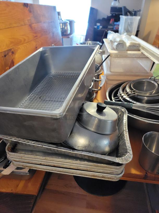 Huge lot of assorted commercial kitchen supplies, including baking trays, pots, and utensils, in used condition.
