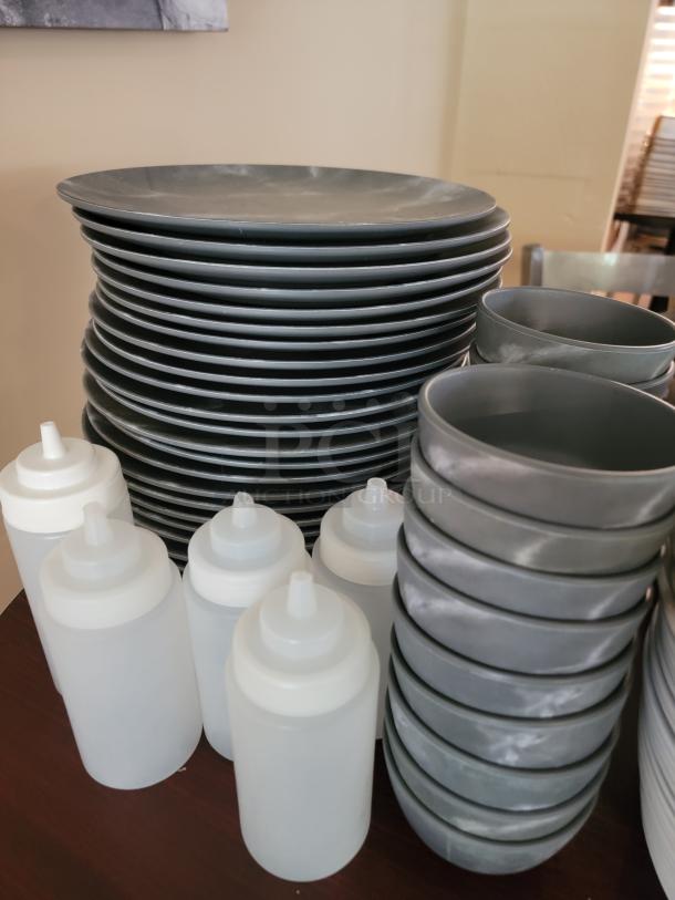 Commercial-grade dinnerware set with gray plates, bowls, and white squeeze bottles; ideal for businesses or large gatherings.