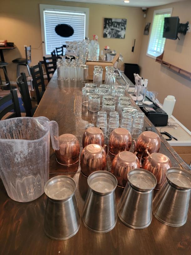Massive lot of commercial-grade glassware, includes varied glasses, copper mugs, and steel cups. Clean and ready for use.
