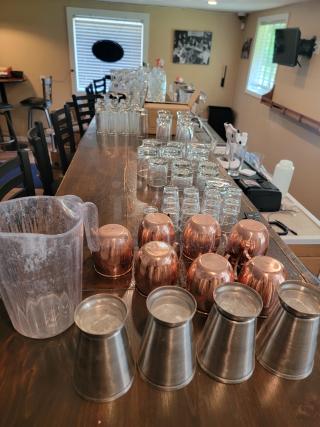 Massive lot of commercial-grade glassware, includes varied glasses, copper mugs, and steel cups. Clean and ready for use.