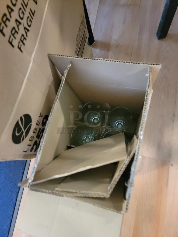 Massive lot of commercial-grade glassware in cardboard boxes, ready for bar or restaurant use. Libbey branding visible. Sparkling clean.