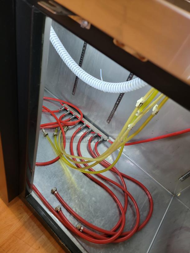 Avantco 178UDD3HC kegerator interior showing red and yellow beer lines, stainless steel surface; designed for commercial use.