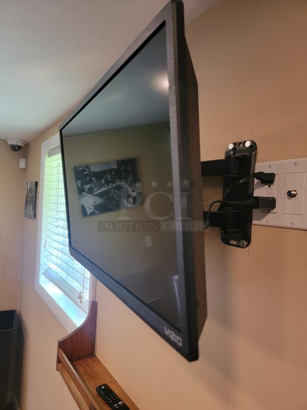 Wall-mounted Vizio TV, model E280B1, in good condition. Includes wall mount and visible Vizio branding on front.