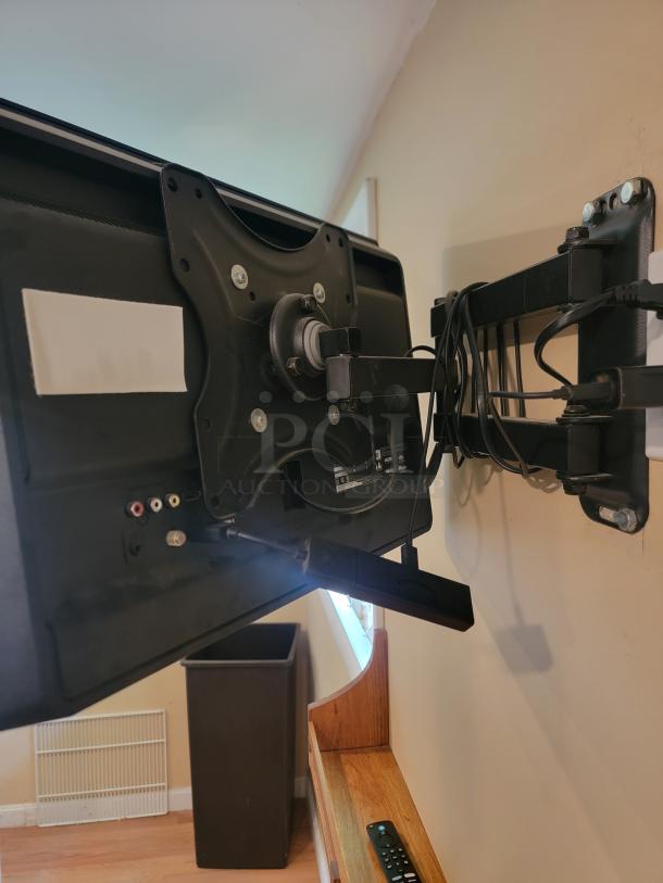 Wall-mounted Vizio E280B1 TV, excellent condition, includes mount. Ideal for home, office, or business use. Cables visible.