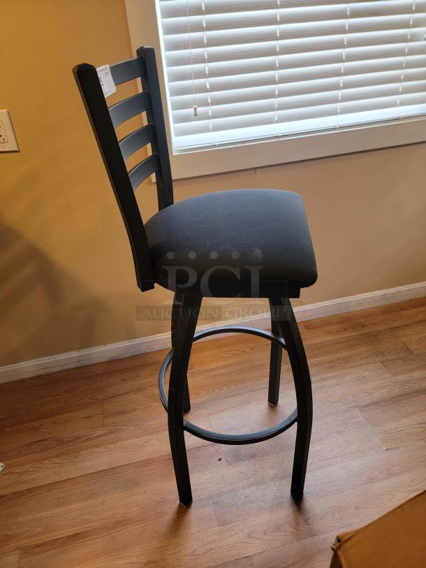 Lancaster 36" black swivel bar chair, featuring a plush padded seat and ladder back design. Ideal for modern bar settings.