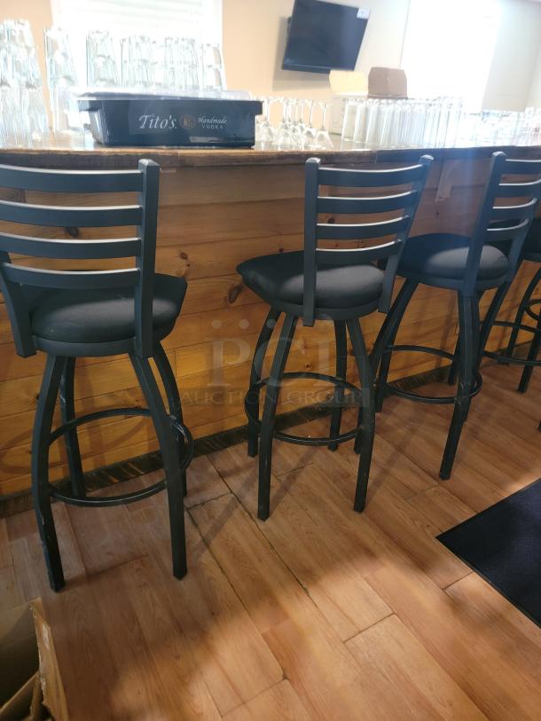 Lancaster 36" black swivel bar chair with plush padded seat, ladder back, and metal frame in excellent condition.