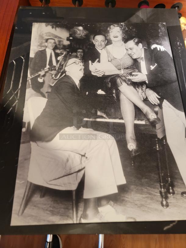 Black and white historical photo featuring a lively group scene, part of an eclectic wall art collection.