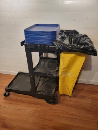 RubberMaid custodial cart with a trash bag holder, supply shelves, hooks, and stacked blue cafeteria trays.