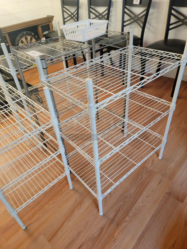 Four assorted 24"x31" metal racks in good condition, featuring sturdy wire construction, suitable for storage.