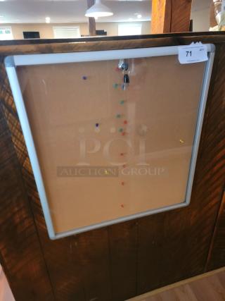 Enclosed cork bulletin board with lock, silver aluminum frame, pinned keys, excellent condition, auction tag visible.