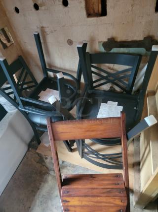 Massive auction lot with various overturned dark chairs and a wooden chair. Includes tags with details, sold as one collection.