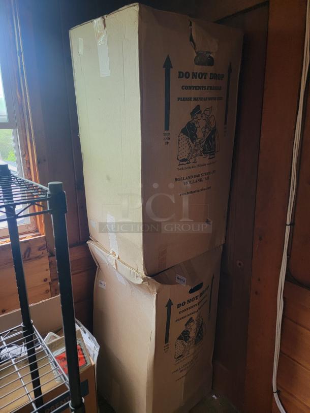 Tall cardboard boxes marked "Do Not Drop," labeled from Holland Bar Stool Co., Holland, MI, indicating office items.