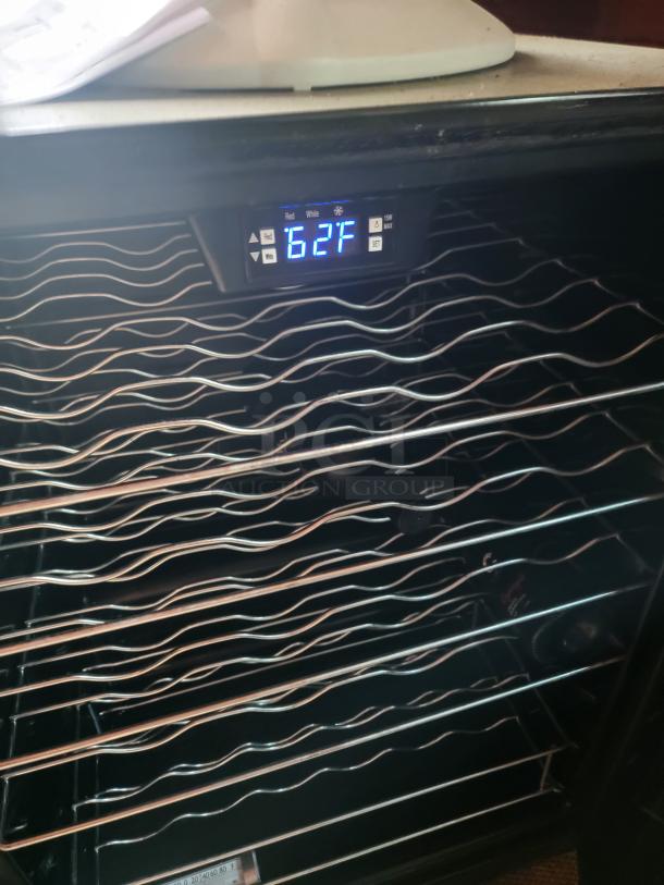 Wine cooler with digital temperature display reading 62°F. Features multiple wire shelves in good condition.