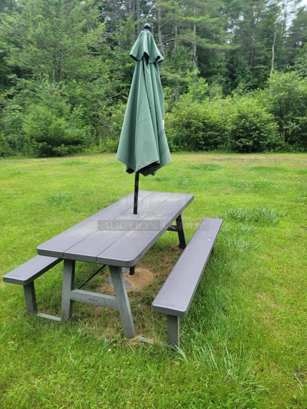 Three Lifetime 6' folding picnic tables with green umbrellas and weighted bases on a grassy lawn. Ideal for outdoor events.