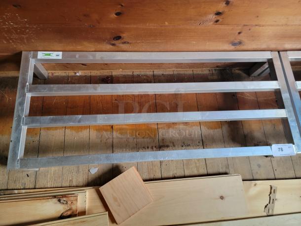 Regency 600DUN2048 stainless steel dunnage rack, used condition, four-bar design, NSF certified label visible.