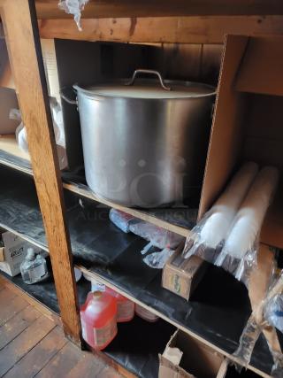 Commercial kitchen supply lot with large stockpot, to-go containers, plastic cups, cleaning supplies, and cookware on shelves.
