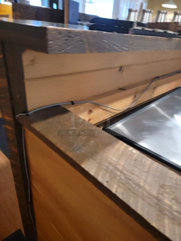 Stunning 18-foot custom wooden bar with rustic finish, ideal for events. Buyer disassembles.