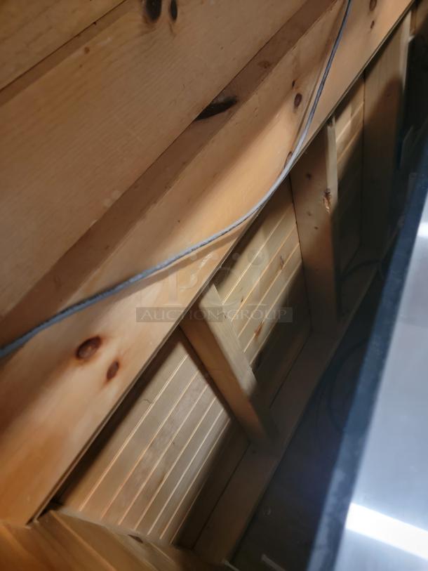 18-foot custom wooden bar with rustic design, featuring sturdy construction and distinctive wood grain. Ideal for events or home use.
