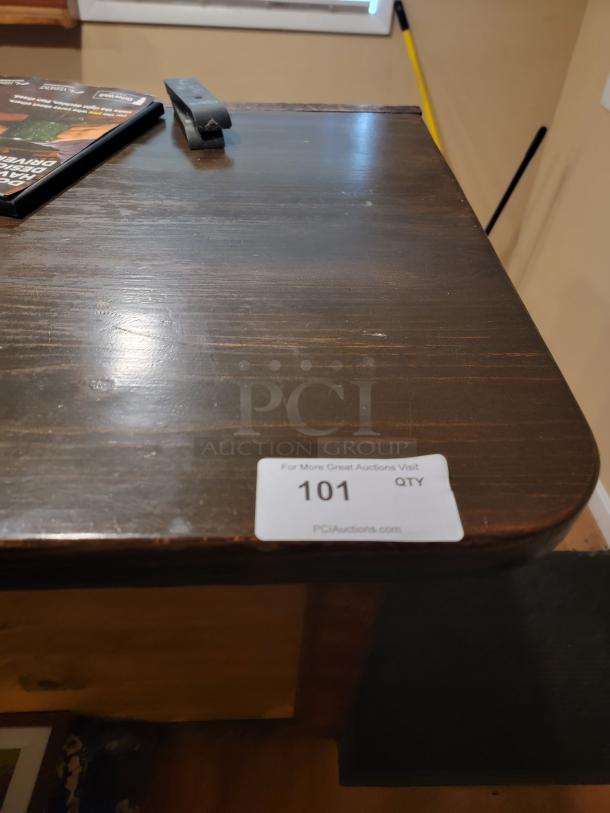18-foot custom wooden bar with rustic finish, seen with sticker reading "101 QTY PCIAuctions.com". Ideal for bar or event space.