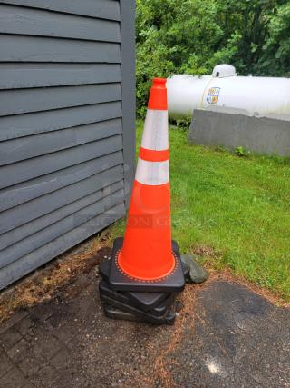High-visibility orange traffic cone with heavy-duty black base, ideal for construction or events. Excellent condition, stable in wind.