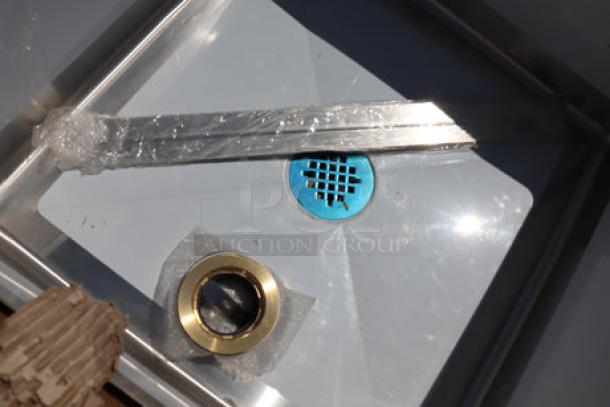 Brand new Regency stainless steel mop sink with notched front bowl, 16-gauge, visible drain components. Scratch & dent condition.