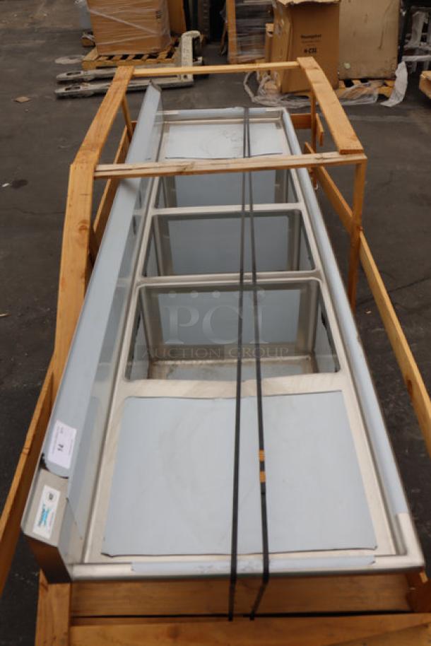 Regency 600S3182424 stainless steel 3-compartment commercial sink with 2 drainboards on pallet. Minor scratches. No legs.
