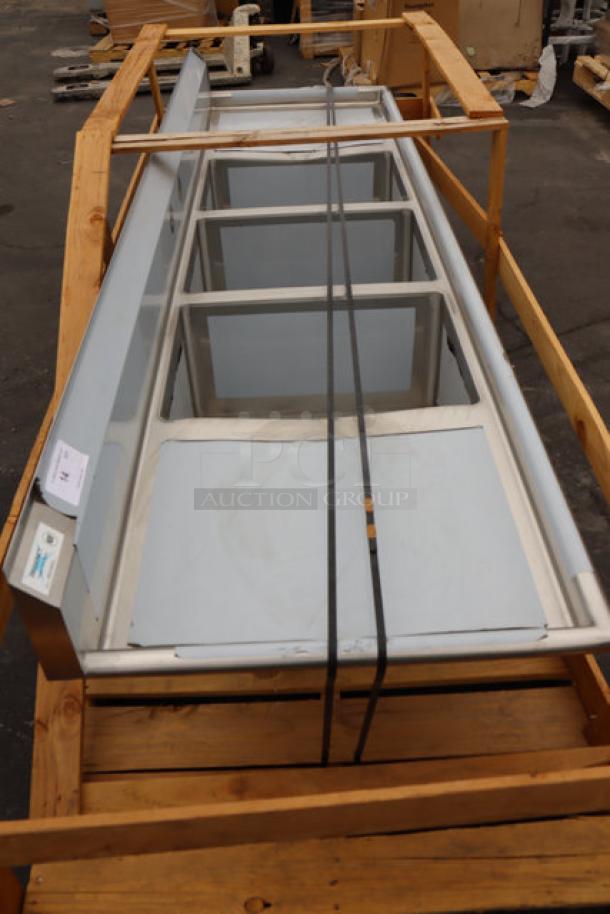 Brand new Regency 600S3182424 94" stainless steel sink with 3 compartments, 2 drainboards, minor scratches, no legs.