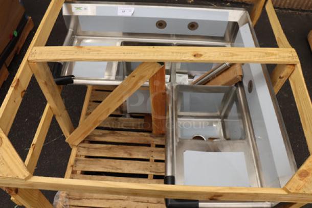 Brand new Regency 600S3141414XC stainless steel corner sink with three 14"x14"x14" bowls, two drainboards, and basket drains.