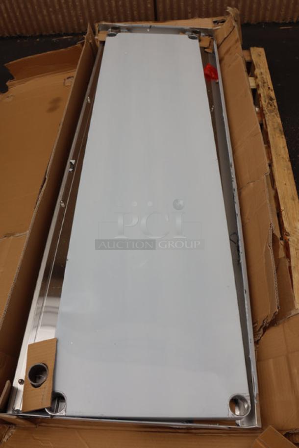 Regency 600TSB2472S 24"x72" stainless steel work table in packaging; minor damage. Features 4" backsplash, undershelf.