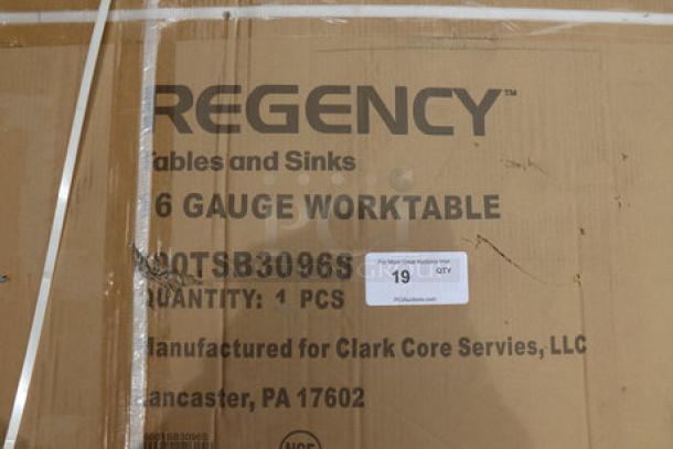 Regency 600TSB3096S work table packaging with damage. Includes product details; table has dents and scratches.