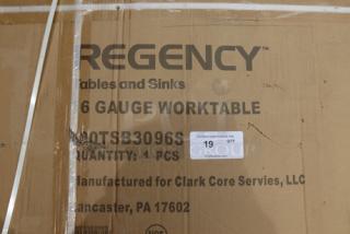 Regency 600TSB3096S work table packaging with damage. Includes product details; table has dents and scratches.