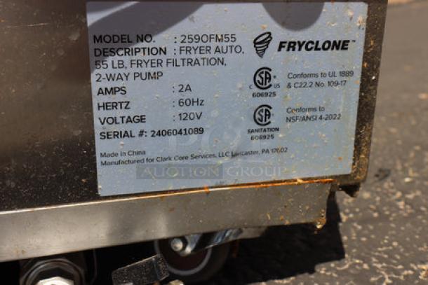 Brand new Fryclone 55 lb. fryer oil filter machine, model 259OFM55, with serial 2406041089; oil spill visible.